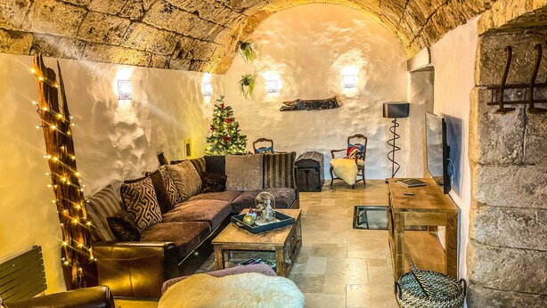 A cozy living room with a stone ceiling, a fireplace, a Christmas tree, and a comfortable seating area. - 1800 Year Watermill 5-bed Farm House in Penaguila (Penaguila)
