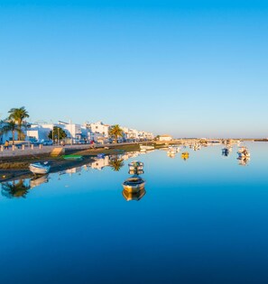 A coastal town with white buildings, calm water, and boats.