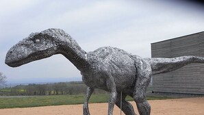 Una grande scultura di dinosauro all'aperto.