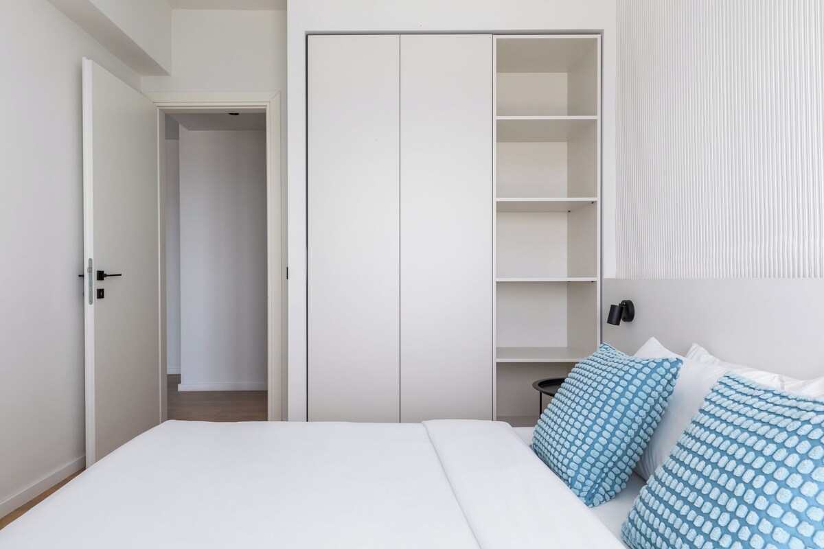 Um quarto com uma cama, um guarda-roupa e uma mesa de cabeceira.