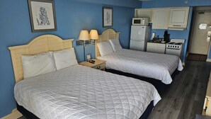 Une chambre d’hôtel avec deux lits, une kitchenette et une salle de bain.