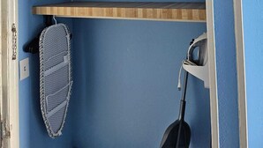 Une pièce aux murs bleus, avec une étagère en bois, un plafond blanc et une porte.