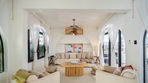 A spacious living room with a sofa set, a coffee table, and a large window with curtains. - Lux 6-bed villa with WiFi, generator and AC in enchanting San Juan, Puerto Rico (San Juan)
