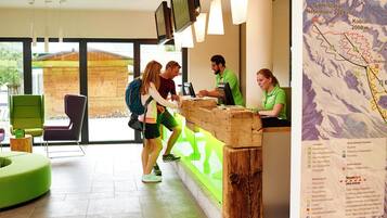 A reception desk with a wooden counter, a map on the wall, and modern seating.