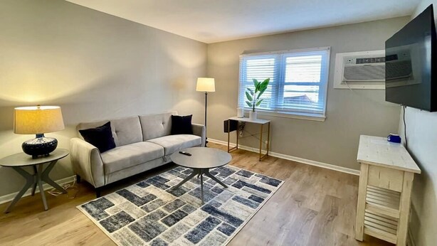Un salon avec un canapé, une table basse, une lampe et un téléviseur.
