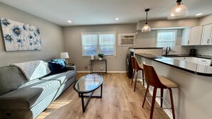 A modern apartment with a living room, kitchen, and dining area.