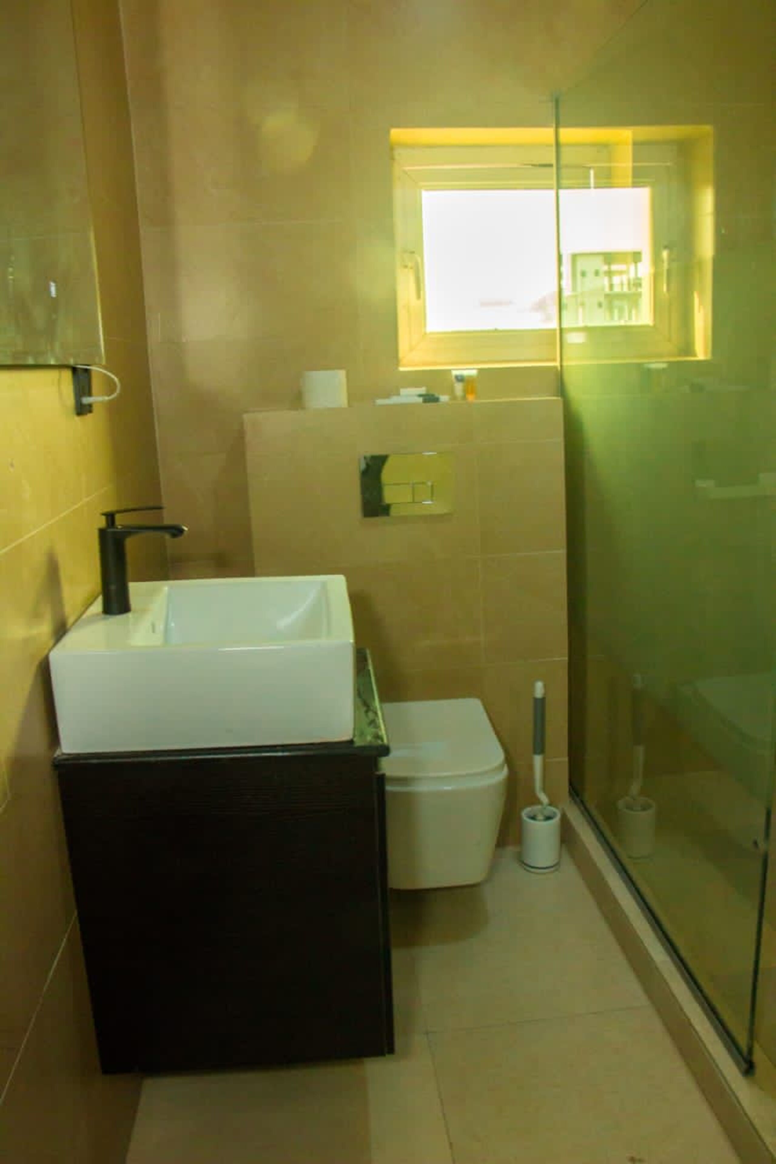 Un baño con lavamanos blanco, inodoro y cabina de ducha de vidrio.