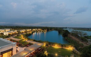 Ein Resort mit mehreren Gebäuden, einem Fluss und einem gepflegten Rasen.