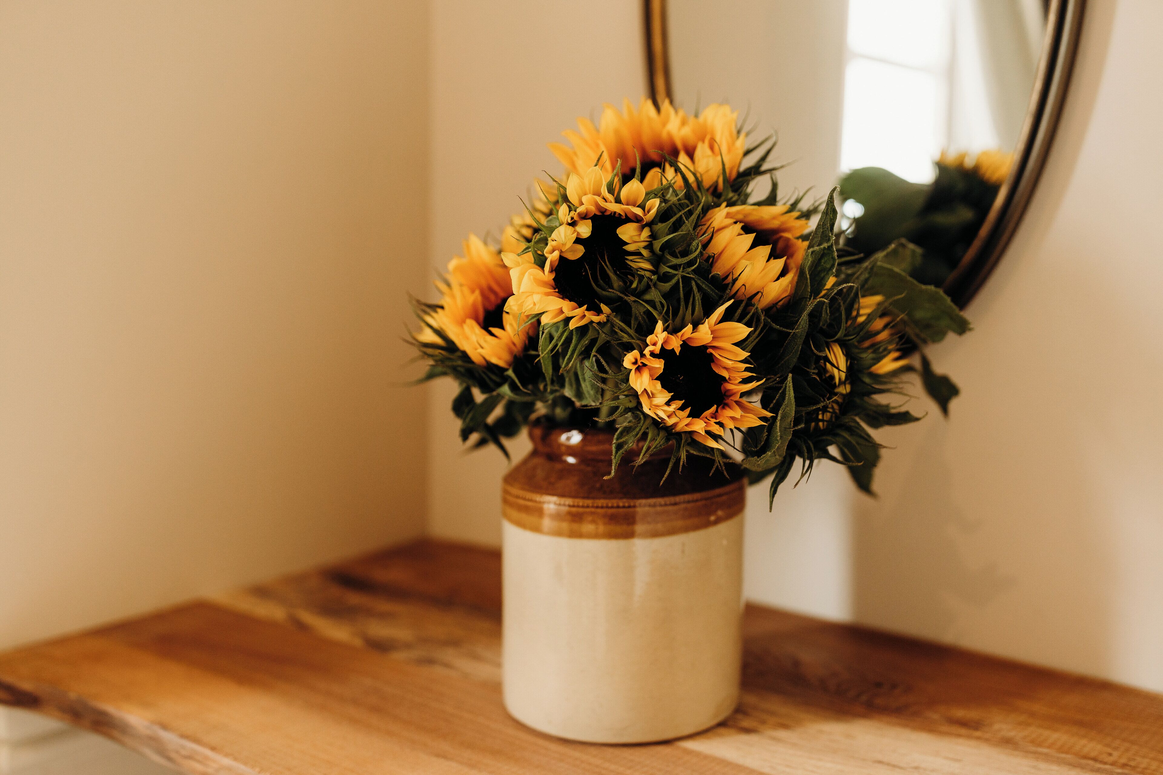 A vase with sunflowers on a wooden surface.