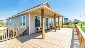 Einbungalow mit überdachter Veranda und einer Holzterrasse.