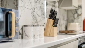 A kitchen counter with a coffee maker, a knife block, and a microwave. - Large 4BR Cowley House, 4 Bath, Sleeps 10 with Parking (Oxford)