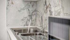A kitchen sink with a modern faucet and a marble backsplash. - Large 4BR Cowley House, 4 Bath, Sleeps 10 with Parking (Oxford)