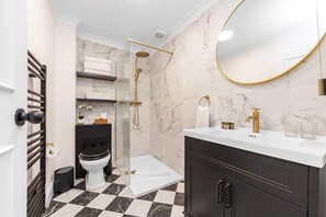 Eenvoudig appartement | Badkamer | Een douche, een haardroger, handdoeken, zeep
