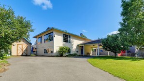A two-story house with a garage, a covered porch, and a well-maintained lawn. - Explore Chugach & Beaches! Anchorage Adventure Pad (Anchorage)