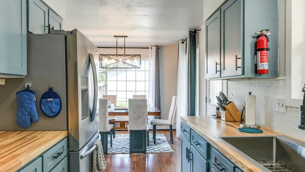 A modern kitchen with grey cabinets, a stainless steel sink, and a wooden countertop. - Explore Chugach & Beaches! Anchorage Adventure Pad (Anchorage)