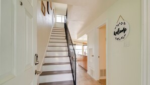 A staircase with a black railing leading to a landing. - Lake Conroe Condo: Balcony, Views & Pool Access! (Willis)