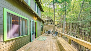 A wooden deck with a dining area, a covered outdoor seating area, and a staircase leading to a second level. - ~ 1 Mi to Dtwn Grand Haven: Lake Michigan Cabin (Grand Haven)