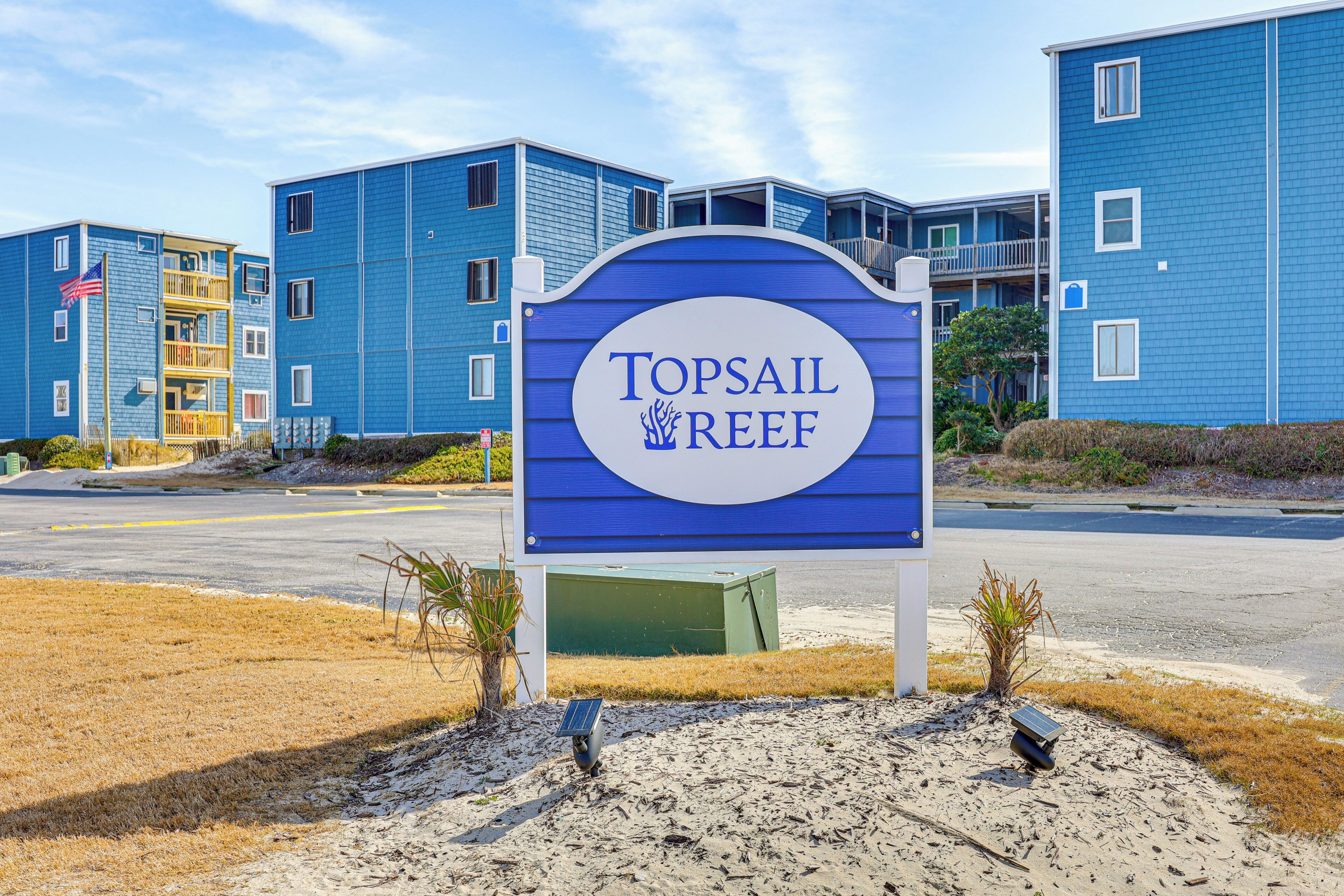 Skilt for Topsail Reef med en blå bygning i baggrunden.