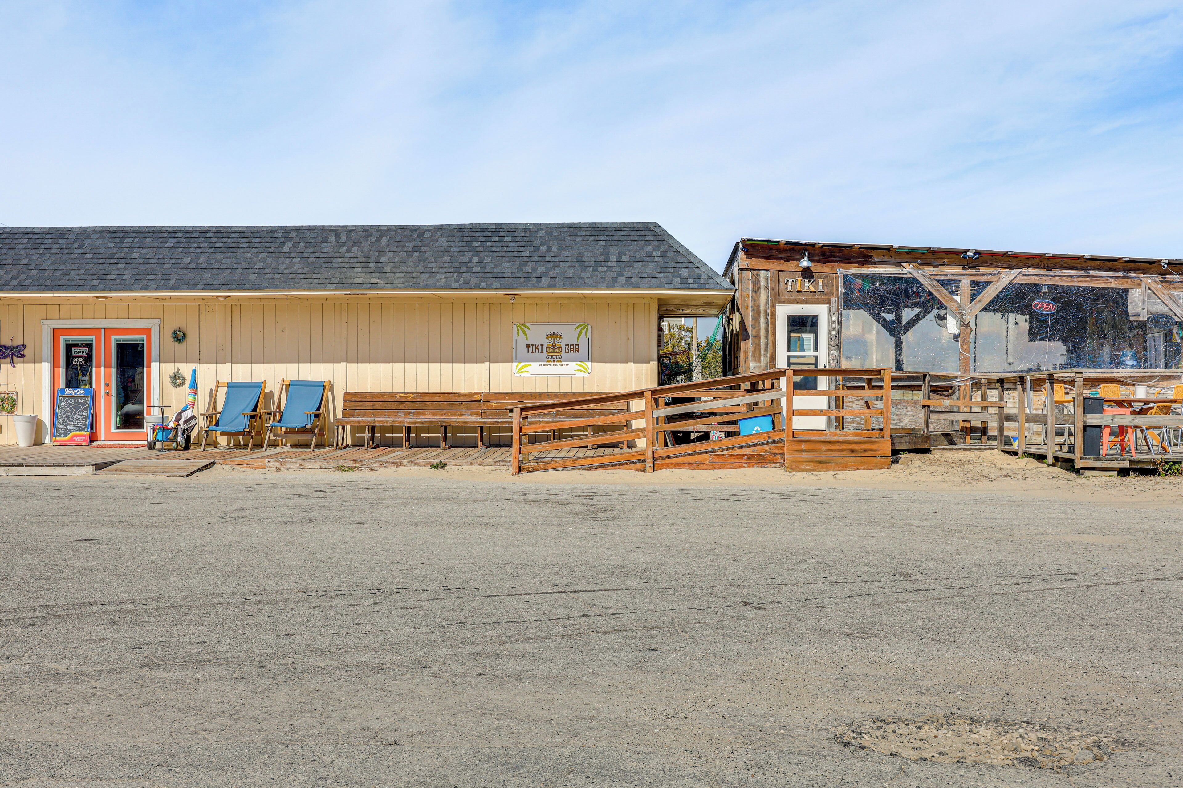 Un bâtiment sur lequel on peut lire l’inscription « TIKI BAR », avec une clôture en bois devant.