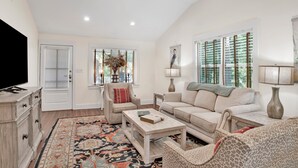 A spacious living room with a sofa, armchairs, a coffee table, and a television. - NEW LISTING! Peaceful, Fairhope Cottage (Fairhope)
