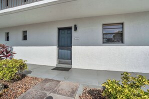 A building with a white exterior, a black door, and a small window. - E-131 -Walk From Lanai to Pool and More (Naples)