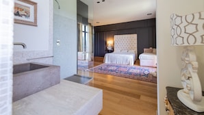 A modern bathroom with a large sink, a bathtub, and a shower area.