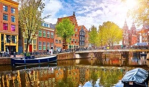 Un canal flanqueado por edificios, un puente y una embarcación.