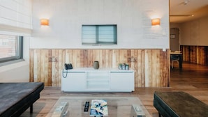 A reception area with a wooden panel wall, a reception desk, a mounted phone, and a window.