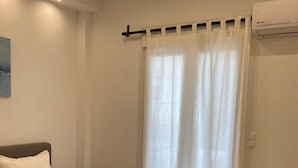 En snyggt bäddad säng med ett brunt överkast och tre hopvikta handdukar.