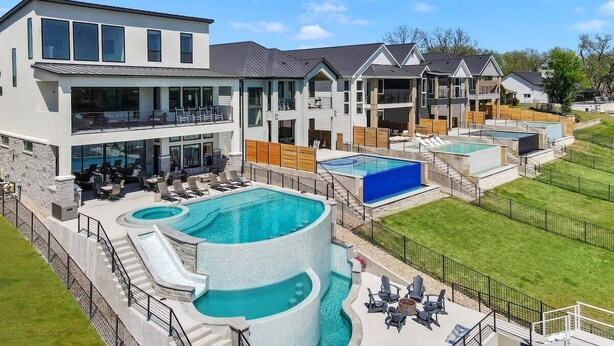 A modern resort with multiple swimming pools, a covered area, and a large building with balconies. - Lone Star Landing II | Concierge Services (Kingsland)