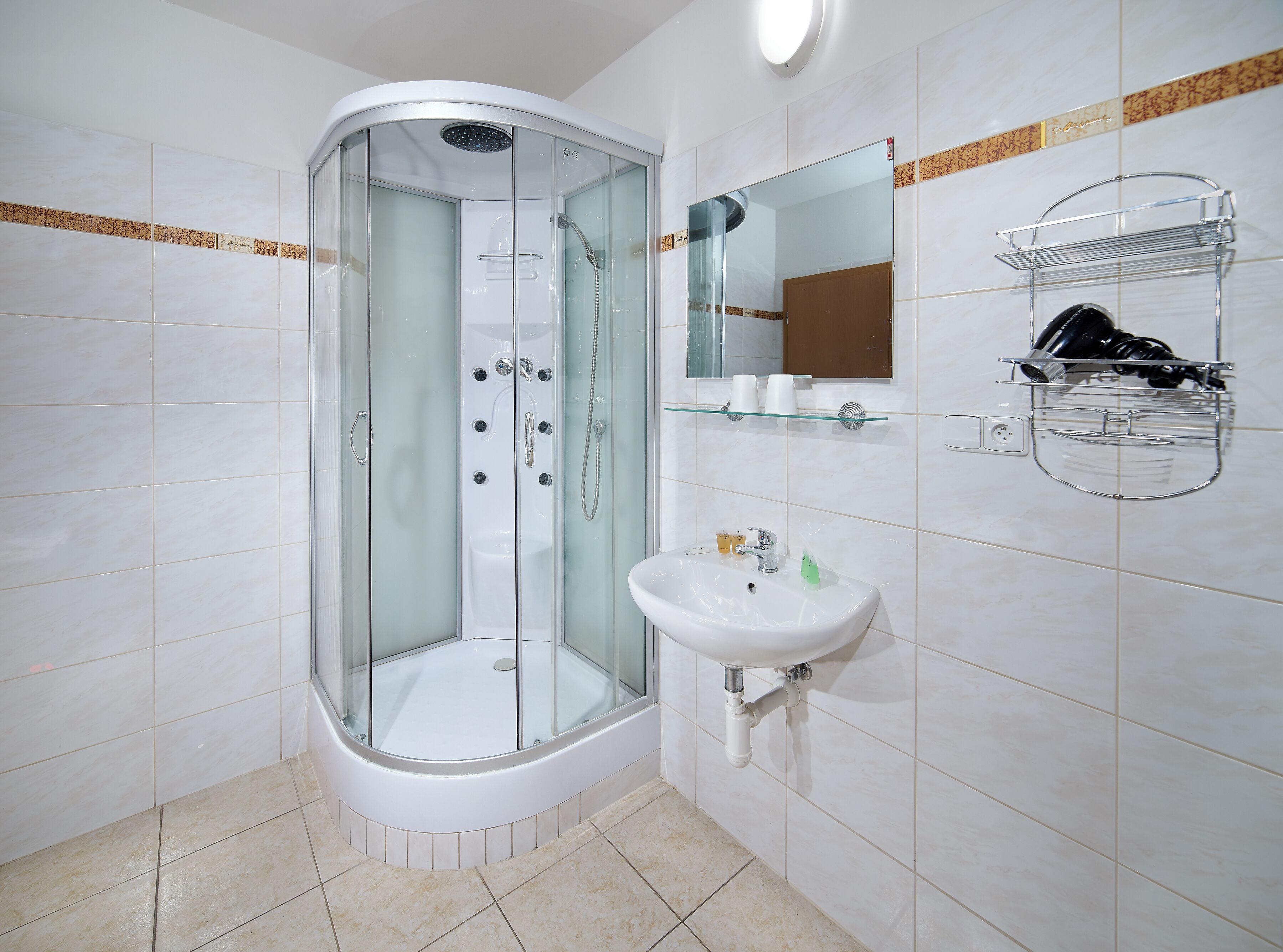 A modern bathroom with a glass-enclosed shower, a white sink, and a mirror above the sink.