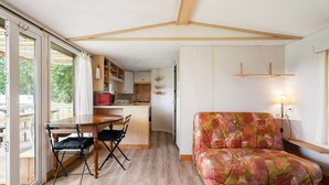 Un espace de vie compact comprenant un coin repas, une kitchenette et un canapé.