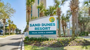 A sign for Sand Dunes Resort advertising villas, suites, and condos. - Gorgeous, Epic Ocean View, & Steps to Beach! Lazy River, Pools, HotTub! (Myrtle Beach)