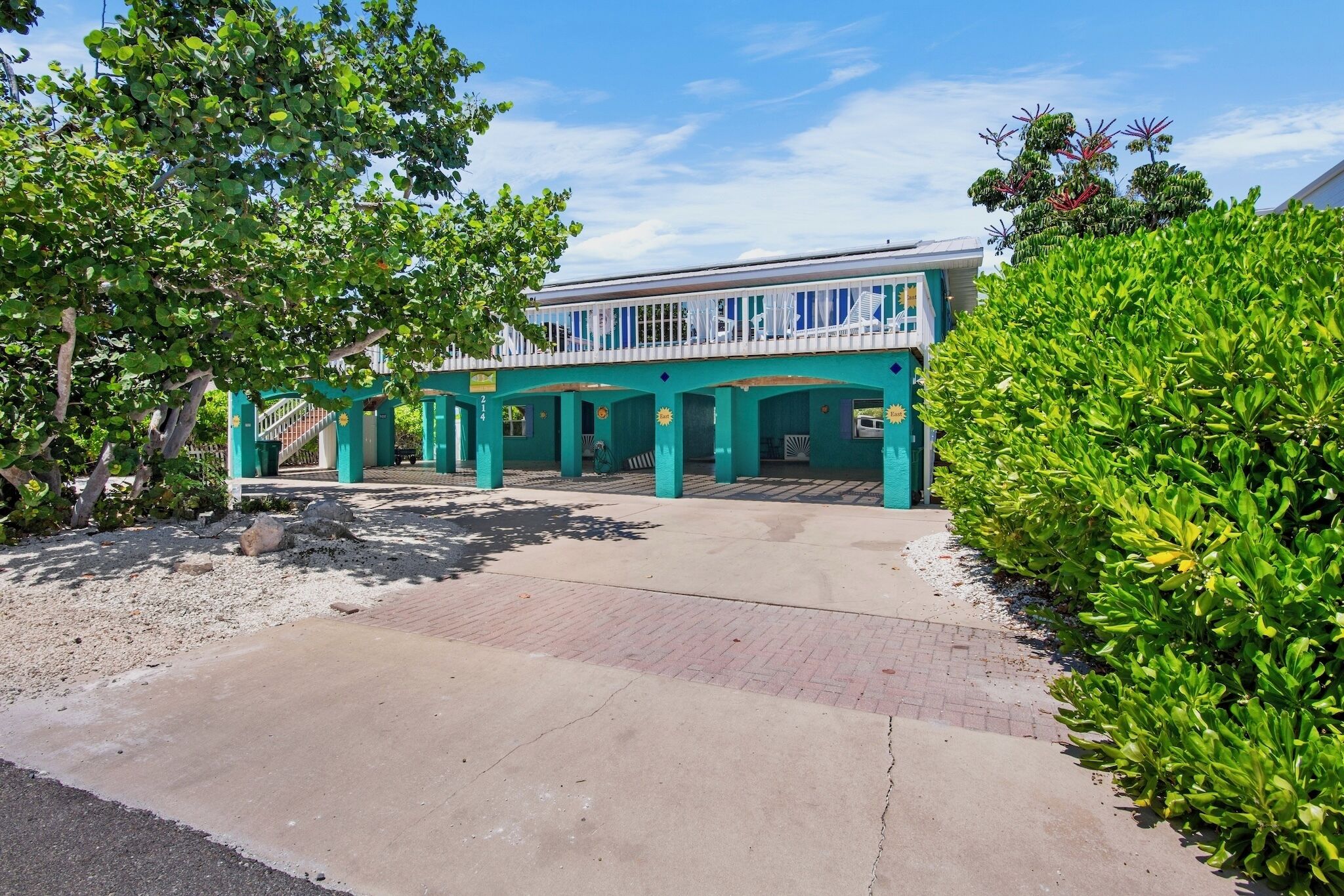A two-story building with a covered patio area and a clear sky.