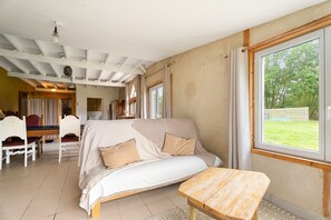 Una stanza con un letto, un tavolo in legno e vista sull'esterno.