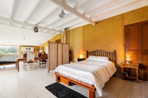 Una camera da letto con un letto, un comodino, una lampada, un armadio in legno e una scrivania con sedia.