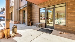 A building with a wooden facade and a large glass door, number 828 visible. - Modern studio with huge balcony overlooking main street in Grand Lake (Grand Lake)