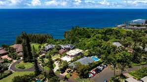 Vista aérea de una zona residencial costera con casas, piscina y vistas al océano.