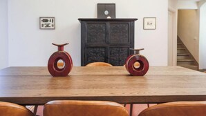 Un comedor con una mesa de madera y sillas de cuero, un armario de madera oscura con intrincados grabados y cuadros en las paredes.