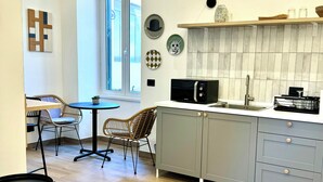 Eine moderne Küche mit grauen Schränken, einer schwarzen Mikrowelle und einem Holzespeisetisch mit Stühlen.
