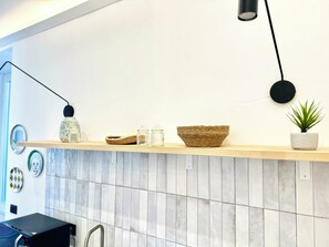 Een minikoelkast, een microgolfoven, kookgerei, borden en bestek