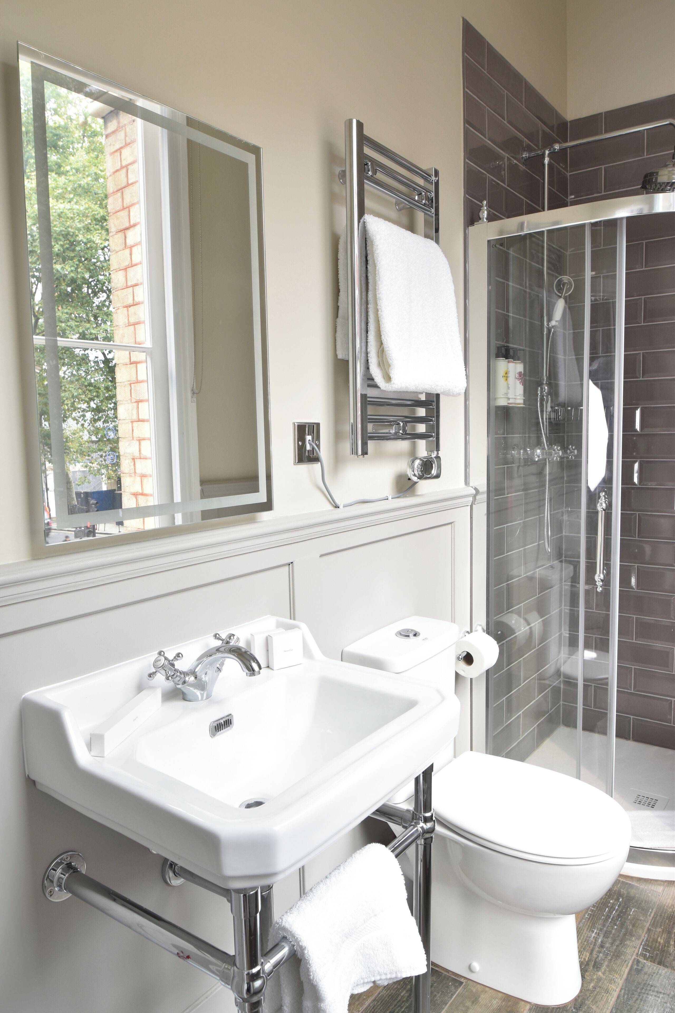 Un bagno moderno con lavandino bianco, water e cabina doccia in vetro.