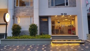 A modern hotel with a glass entrance, a reception desk, and a sign indicating room rates. - HOTEL SANTORI (San Juan de Pasto)