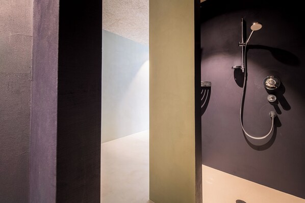 A modern bathroom with a shower, a towel rack, and a toilet.