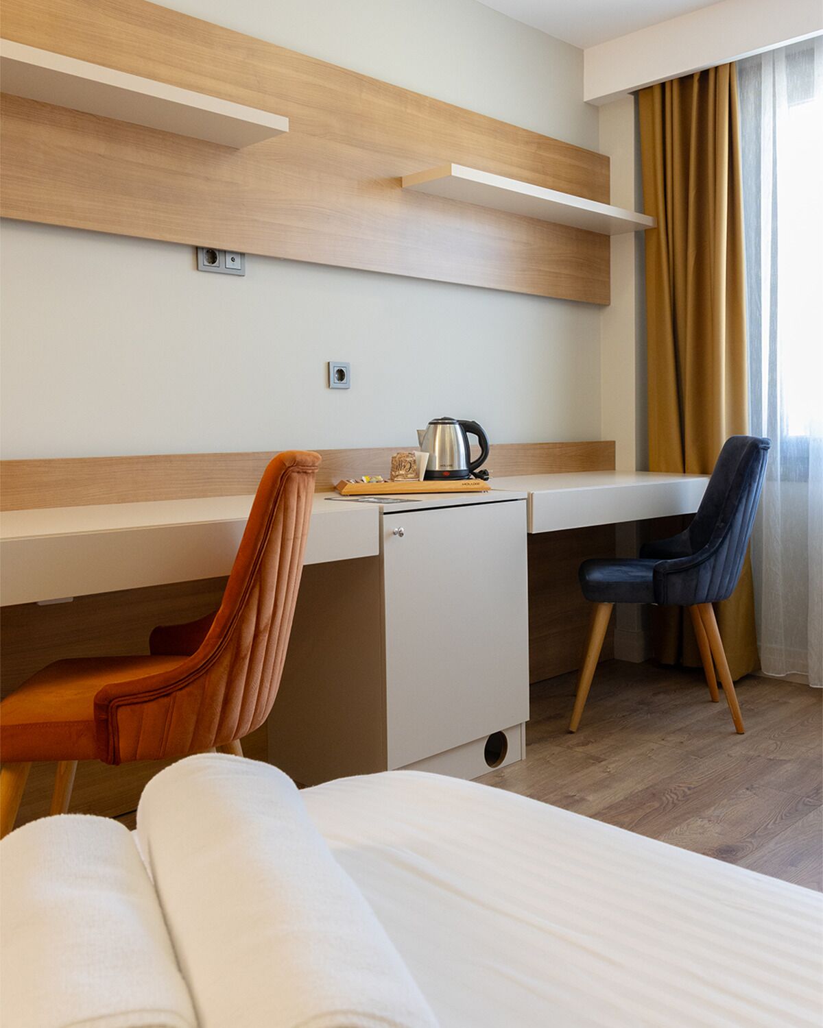Une chambre d’hôtel équipée d’un lit, d’un bureau, d’une chaise et d’une machine à café.