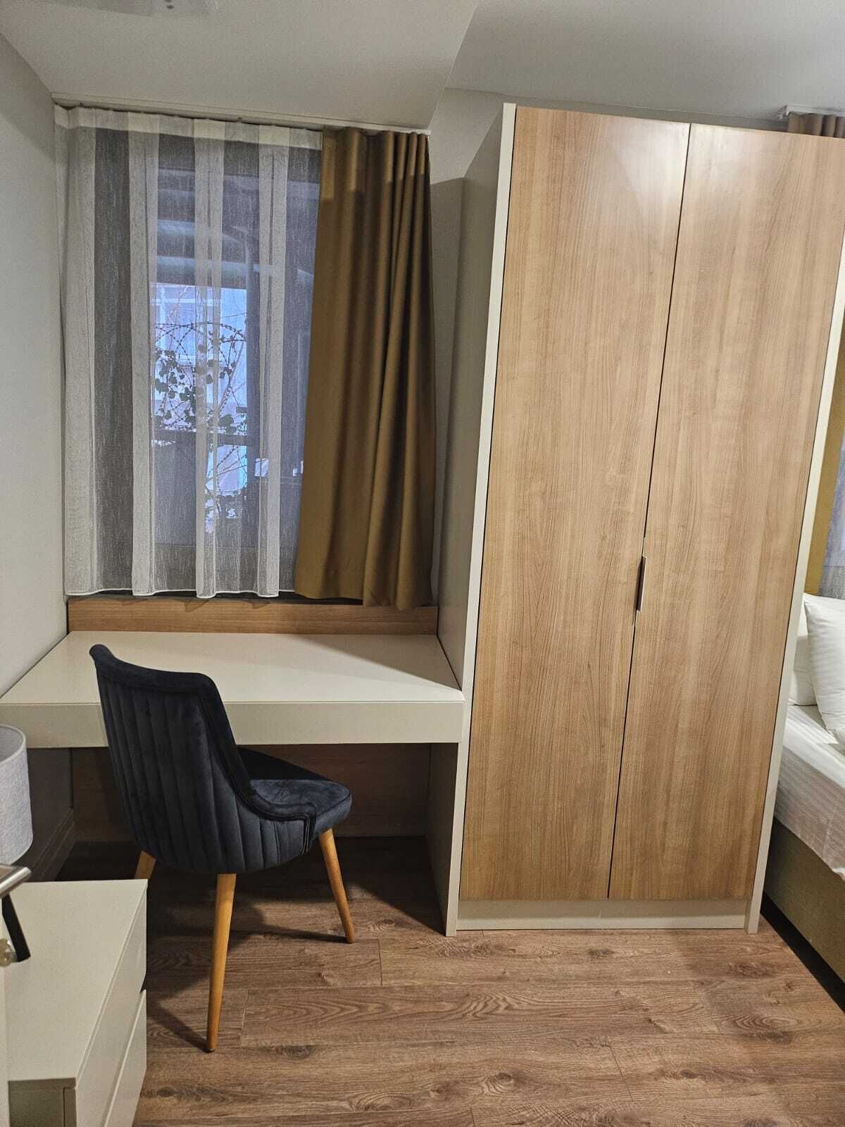 Un dormitorio con cama, escritorio y armario.