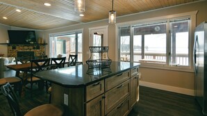 A kitchen with wooden cabinets, a central island, and pendant lighting. - Spruce Haven (Hayward)