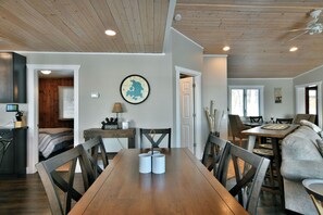 Enjoy meals in this dining area with a table for four, surrounded by a high ceiling and comfortable seating.