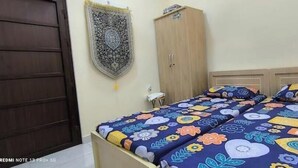 Un dormitorio con una cama, un armario y un cuadro en la pared.