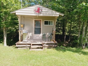 A small cabin with a porch, a window, and a door. - Newly Renovated Cabin on a Private Lake Great for a Romantic Getaway or some R&R (Second Eel River Lake)